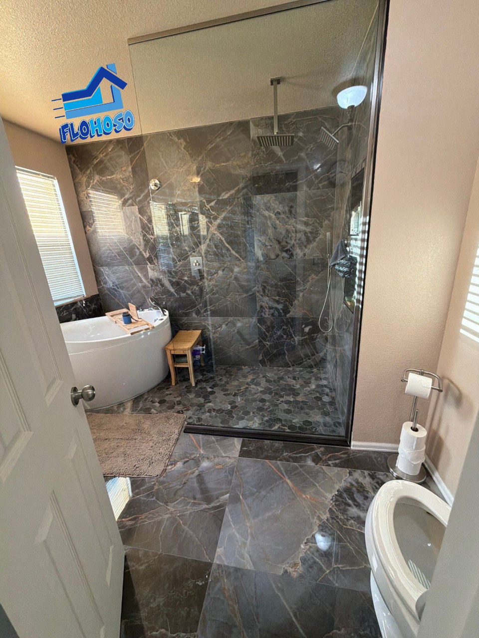 Luxury bathroom remodel with dark marble tile walk in shower and freestanding tub