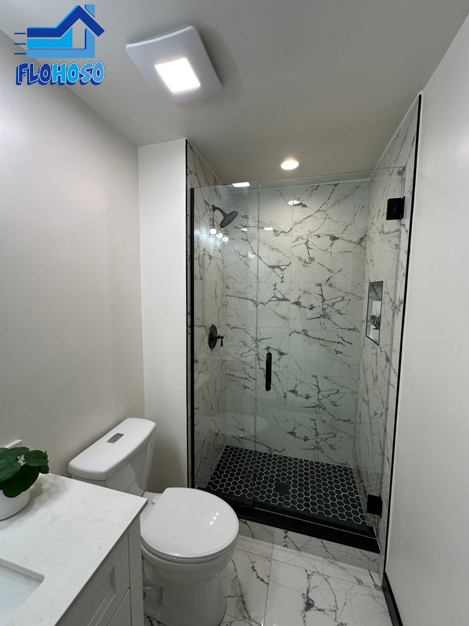 Modern white marble shower remodel with black fixtures in Denver CO
